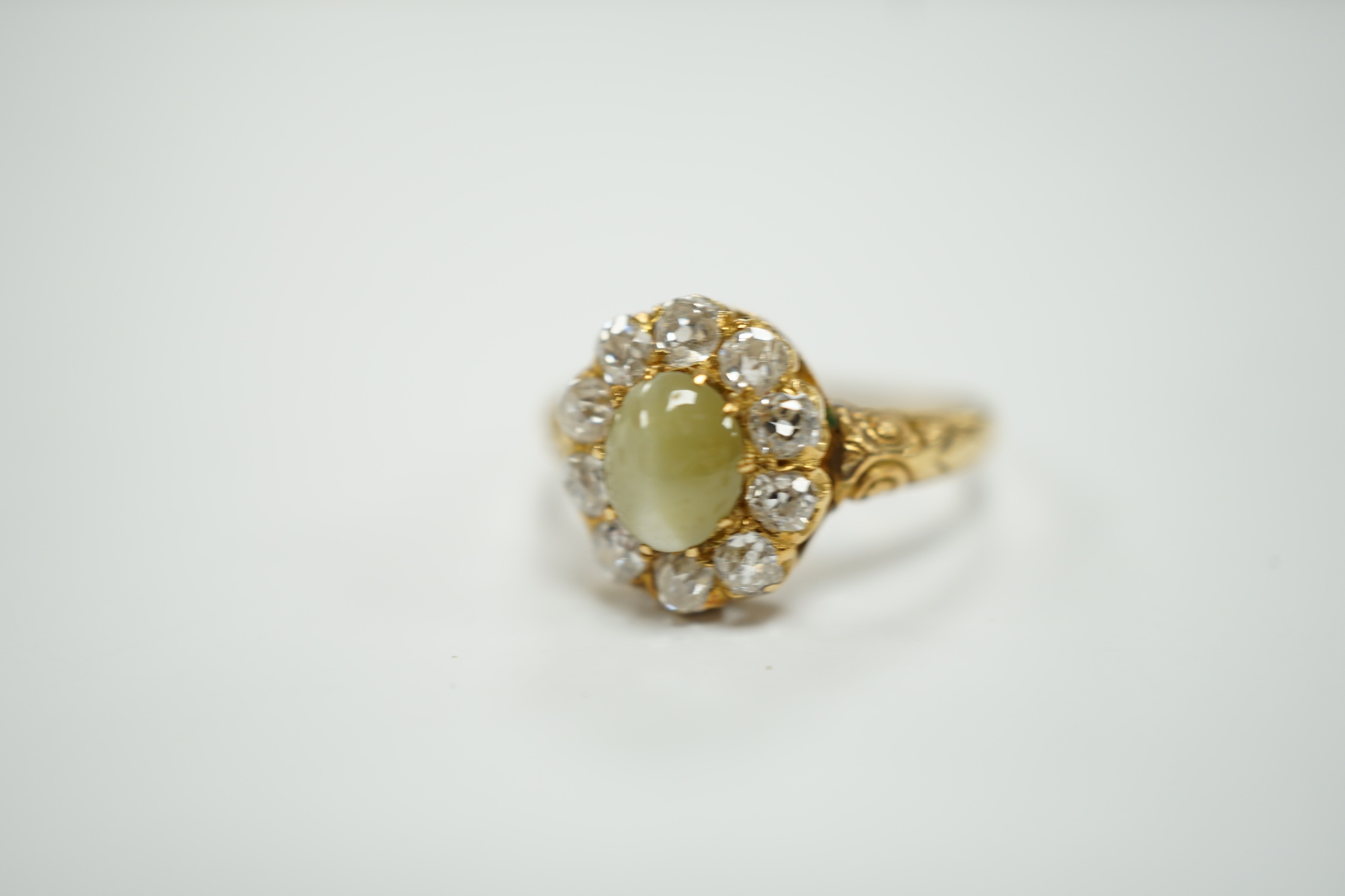 A yellow metal, cat's eye chrysoberyl and diamond cluster set ring, size L, gross weight 2.9 grams.